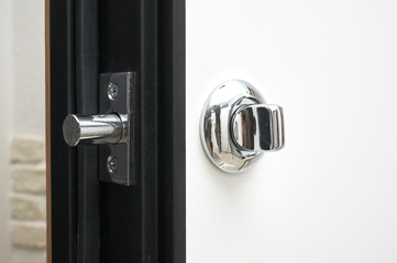 steel lock and chrome handle in a metal door finished with wood