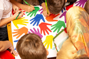 Children draw on a poster, a view from the top