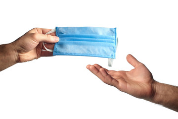 Male hand holds home-made medical mask to another on white isolated background