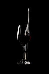 Bicchiere di vino con bottiglia su sfondo nero