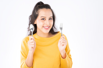 Young beauty Asian woman showing spoon and fork prepare to eat food and she wearing a yellow sweater shot isolated on white background