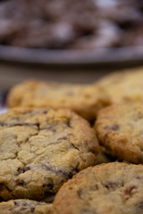 Bolacha com gotas de chocolate focado a frente e desfoque no fundo