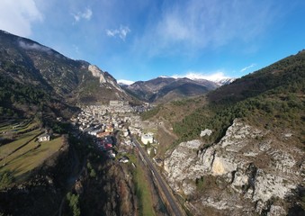 Aerial panoramic drone view of a scenic highway by the beautiful Landscape covered in clouds and fog, bridge and viaduct, The mountain river along the road, Snow-covered mountains on a background