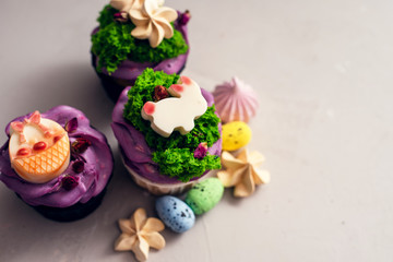 Easter cupcakes with different decorations made of chocolate and cream on a gray background