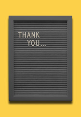 Black message board Thank you on the yellow background