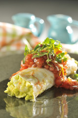 Guacamole wrapped in a layer of white shrimp with sweet pepper and herbs 