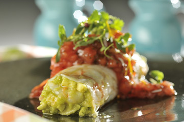 Guacamole wrapped in a layer of white shrimp with sweet pepper and herbs 