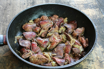 Fried livers with onions in a black pan