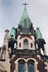 Fototapeta na wymiar Roof with a green copper roof. Olga and Elizabeth church in Lviv. Baroque and Gothic architecture. Steeples on the towers. Lviv, Ukraine