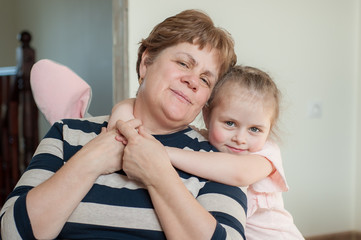 Grandmother 60 years old and granddaughter together at home. Take care of your family, stay home, coronovirus