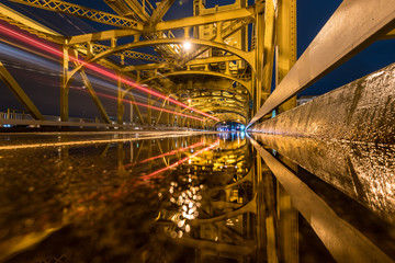 Light streaks and reflections on a gold bridge.