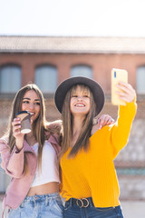 Two Female Friends Taking a Selfie Outdoors.