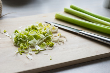 Sliced green onions on a wooden Board. Bright kitchen.