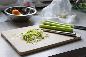 Sliced green onions on a wooden Board. Bright kitchen.