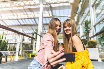 Two Female Friends Taking a Selfie Indoors.