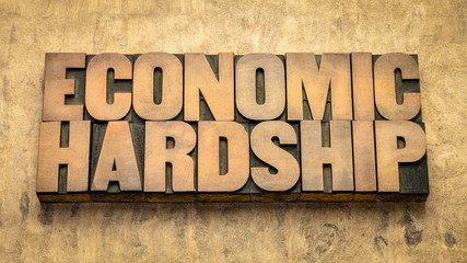 economic hardship word abstract in  wood type