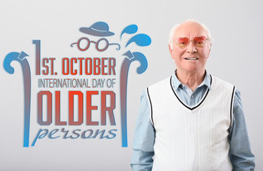 Portrait of happy elderly man on grey background. International day of older persons