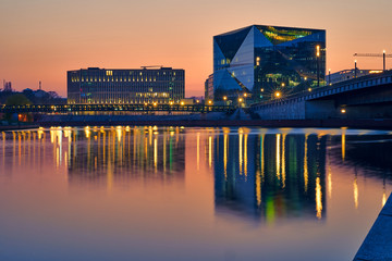 beautiful panoramic view at sunset, Berlin Spreebogen at Hugo-Preuss Bridge with a view of the Cube Berlin and John F. Kennedy House building at the main train station and the river Spree, orange sky