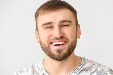 Fototapeta premium Happy young man with healthy white teeth and beard laughing joyfully, expressing positive emotions and dental health, his facial expression conveys positive emotions and overall well being