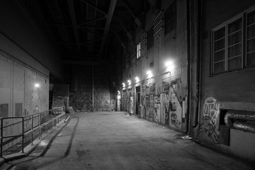 Depressing dark alley with graffiti in grayscale