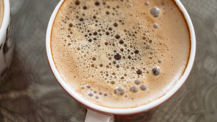 cup of coffee with bubbles on the surface fragment blurred background