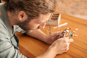 Jeweler examining gemstone in workshop