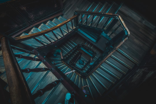 Very Beautiful Vintage Wooden Stairs Or Staircase In Blue And Brown Color In One Of The Buildings In Lviv, Ukraine. Hands Are Seen Holding The Wooden Railing Going Up The Stairs. Spiral View