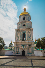 Fototapeta na wymiar Bell tower of Sant Sophia cathedral in Kiev, Ukraine, viewed from below a sunny day in summer with sun directly behind the spire