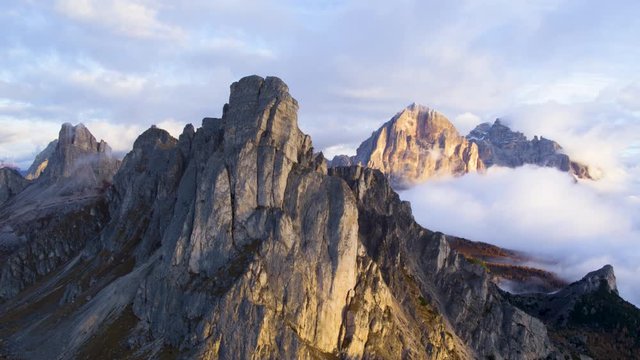 Aerial view of majestic dolomites mountains summit in the autumn sunset sun hidden behind the clouds. Golden hour.