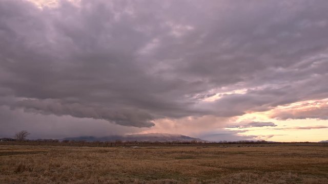 Wall cloud moving over the landscape during sunset in Utah bringing a dark storm.