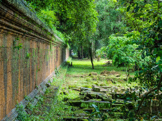 Ancient orange and green wall in perspective and green forest, Angkor Wat, Siem Reap, Cambodia