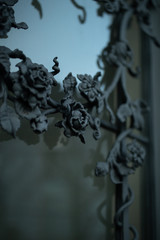 Fototapeta na wymiar Elements of architectural decoration of buildings, an old metal forged door. Forged roses. Selective focus
