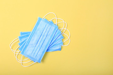 Medical masks for protection against flu and coronavirus on yellow background.