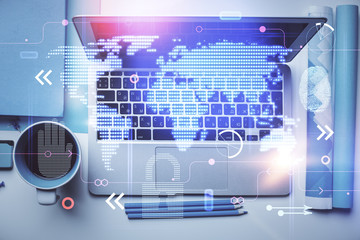 Double exposure of map hologram drawing over study table background with computer. Concept of international network. Top view.