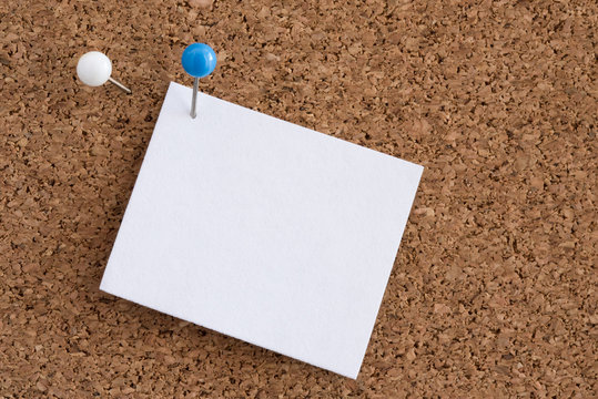 A Pin Holding Blank Paper to a Cork Board