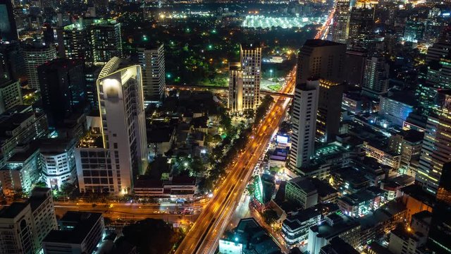 Traffic at night during rush hour, Bangkok business district city center, with buildings and skyscrapers, zoom out – Time Lapse
