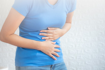 Young beautiful woman having painful stomachache on white background.Chronic gastritis. Abdomen bloating concept.