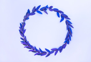 Creative neon background with leaves. Colorful abstract backdrop with frame of plants and space for text. Exotic nature branch with blue and purple vivid colors. Organic twigs with shiny illumination