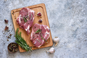 Striped steak on a wooden board with spices on a concrete plate. Ingredients for cooking.