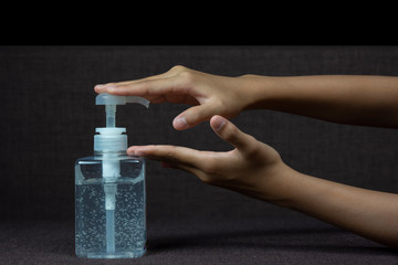 Child girl uses  her hand to press hand sanitizer bottle to clean her hand. Concepts of Flu virus, Covid-19 (Coronavirus disease). Can used for microbiology concept or medical healthcare.