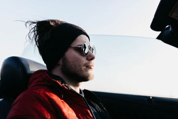 male cabriolet car driver rides in sunglasses steampunk style on a sunny day.