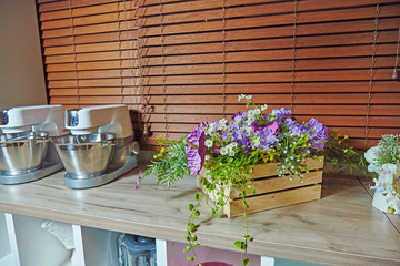 Fototapeta na wymiar Kitchen decorated with plastic flowers in wooden box