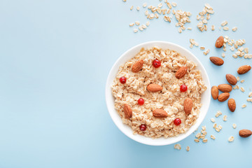 Bowl with tasty sweet oatmeal on color background