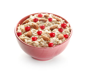 Bowl with tasty sweet oatmeal on white background