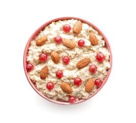 Bowl with tasty sweet oatmeal on white background