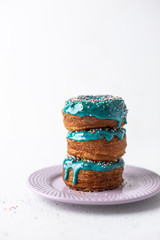 Puff pastry donuts cronuts with blue icing on white background