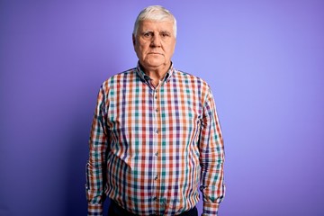 Senior handsome hoary man wearing casual colorful shirt over isolated purple background Relaxed with serious expression on face. Simple and natural looking at the camera.