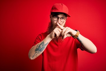 Fototapeta na wymiar Young handsome delivery man wearing glasses and red cap over isolated background Rejection expression crossing fingers doing negative sign