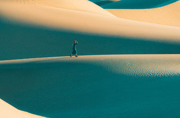 Woman walking on sand dunes