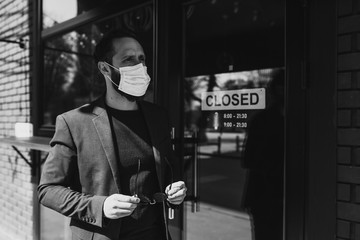 Fototapeta na wymiar Handsome man with beard in trendy formal suit wearing a medical face mask as a precaution from viruses infection. Coronavirus - 2019. 
